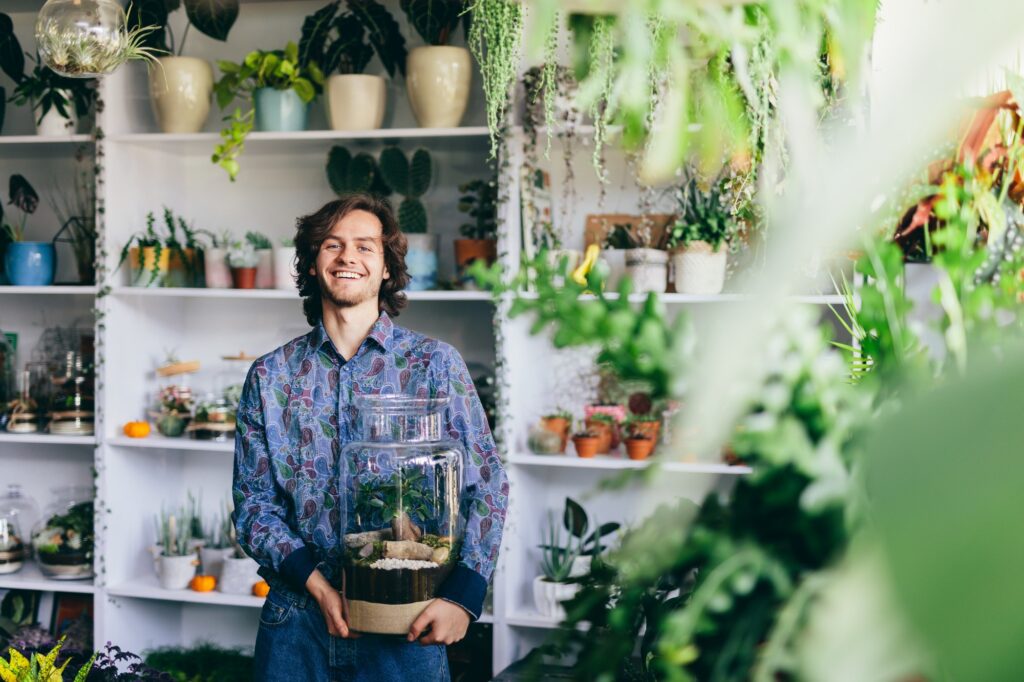 Happy man with plants in glass jar.