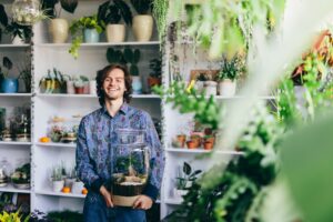 Happy man with plants in glass jar.