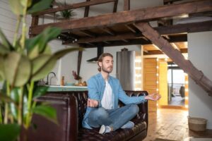 Concentrated man practicing meditation at his appartment