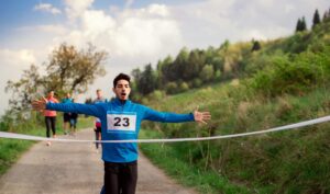 Man runner crossing finish line in a race competition in nature