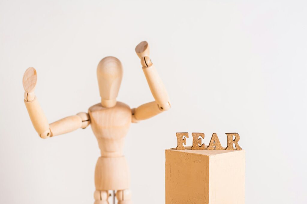 The word fear and a wooden man throwing up his hands in horror